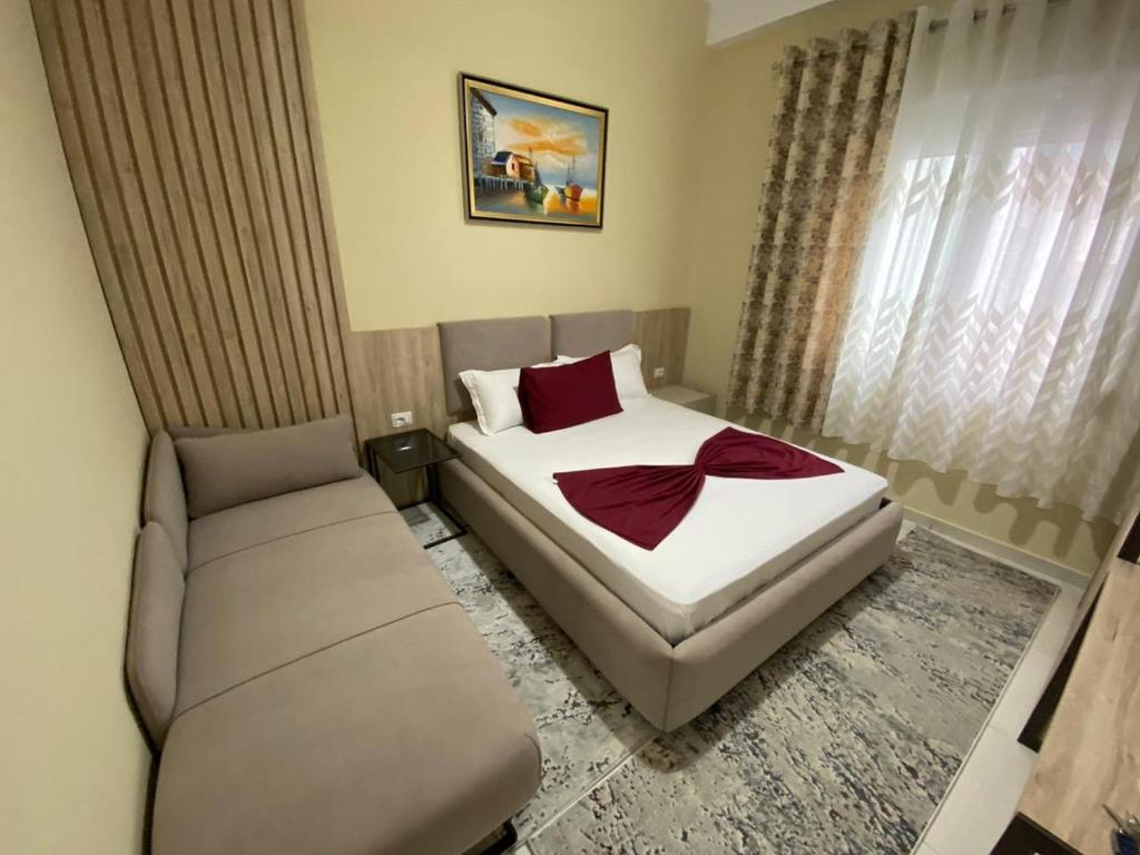 ein Schlafzimmer mit einem Bett und einem Sofa in der Unterkunft Kevin’s Lungomare Apartment in Vlorë