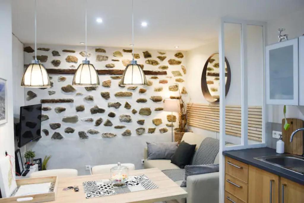 une cuisine et un salon avec une table et un canapé dans l'établissement Gîte urbain ancienne écurie au centre ville et PARKING, à Nantes