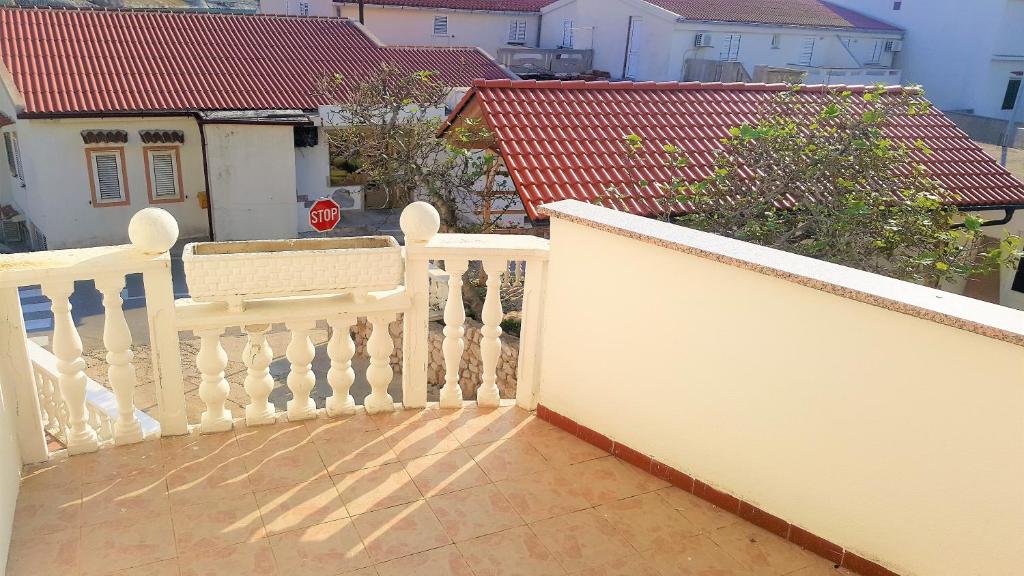 a balcony with a white railing and a stop sign at Apartments Niko Metajna, island Pag in Metajna