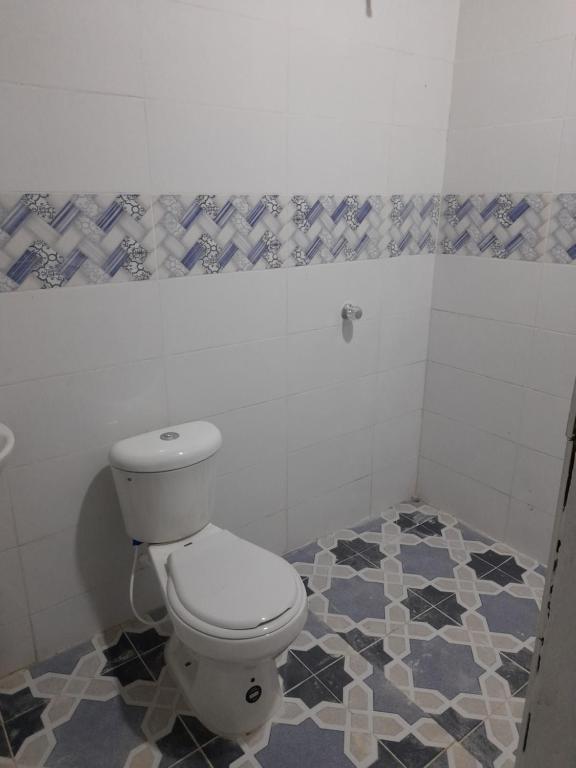 a bathroom with a toilet and a tiled floor at Hospedaje Rural Amanecer Llanero in Restrepo