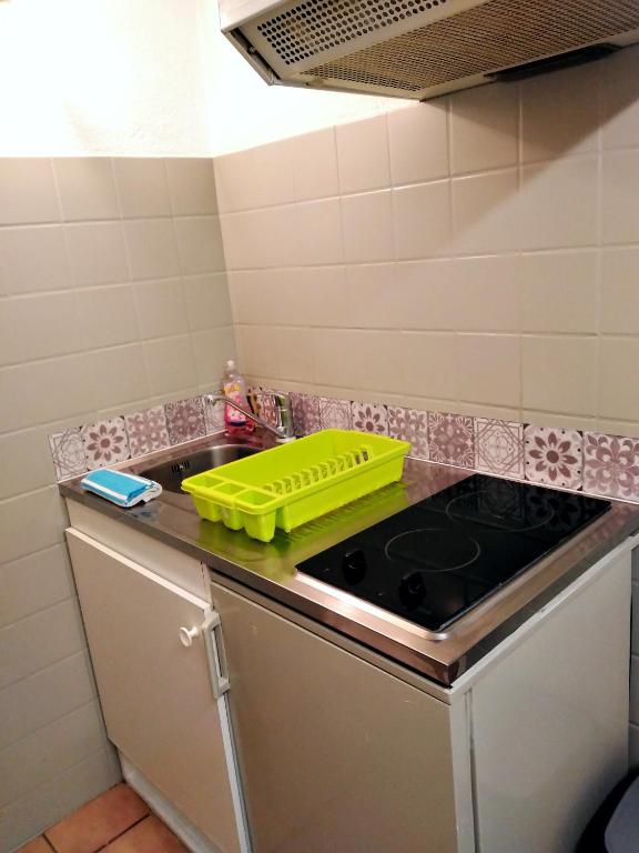 a kitchen with a sink and a yellow container on the counter at Appartement T1 quartier château de Pau in Pau