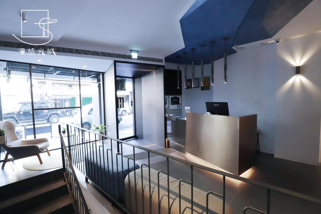 a lobby with a counter and a chair in a building at Slow Town Hotel-Glowing in Taichung