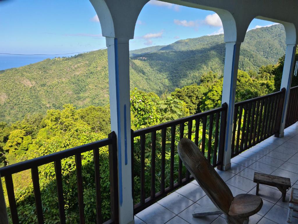 a porch with a chair and a view of the mountains at Peaceful House in Vieux-Habitants