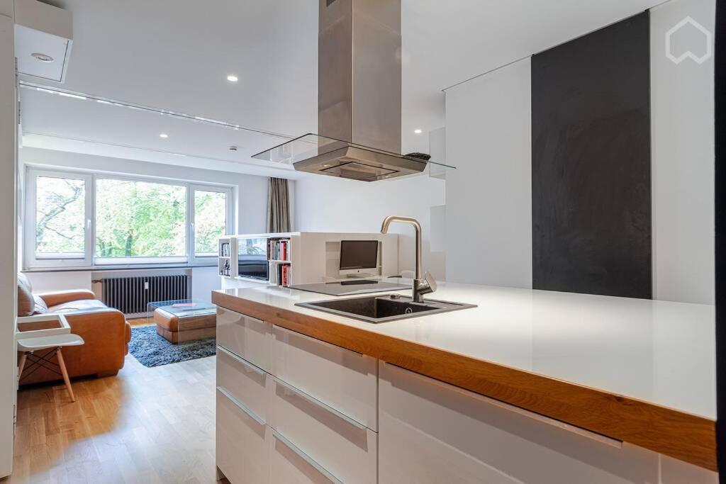 - une cuisine blanche avec évier et four micro-ondes dans l'établissement Alster 36 - Exklusives City Apartment, à Hambourg
