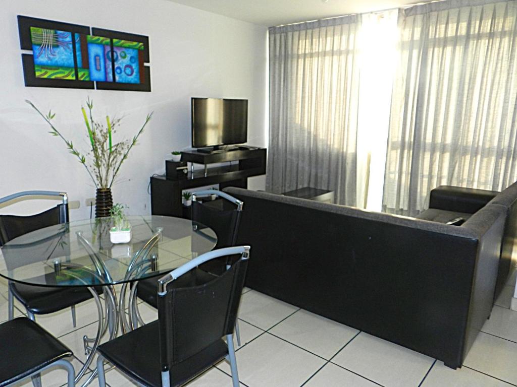 sala de estar con mesa de cristal y sofá en Departamento Marifer, en Tacna