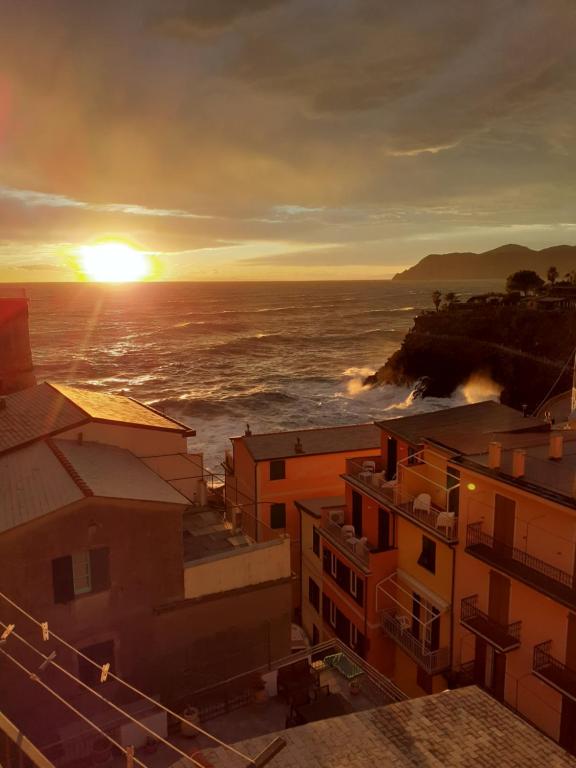 een zonsondergang over de oceaan met gebouwen en de oceaan bij Il Patio in Manarola