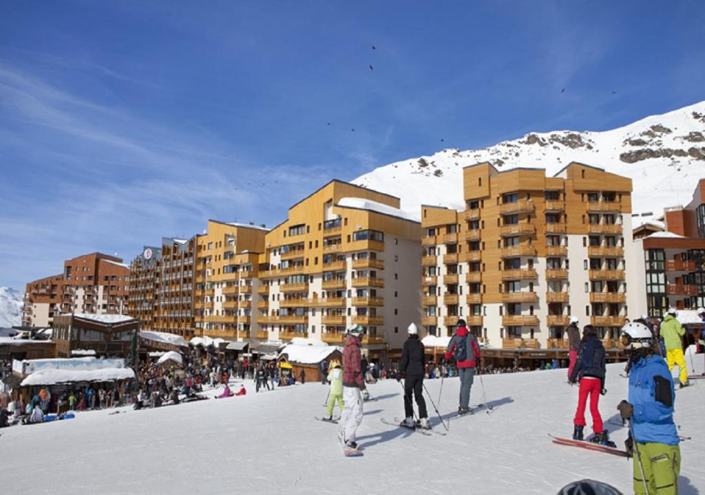 a group of people standing in the snow in front of a hotel at Résidence Olympiades in Val Thorens