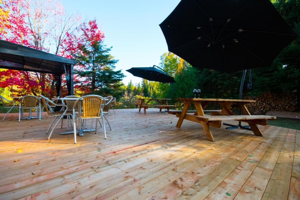 a patio with tables and chairs and an umbrella at Oberge Inn Val-David in Val-David