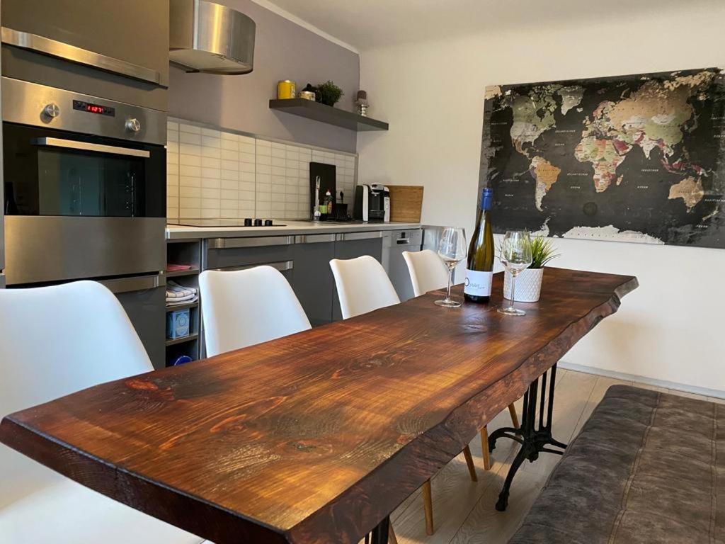 a kitchen with a wooden table and white chairs at My Happy Place in Ochsenfurt