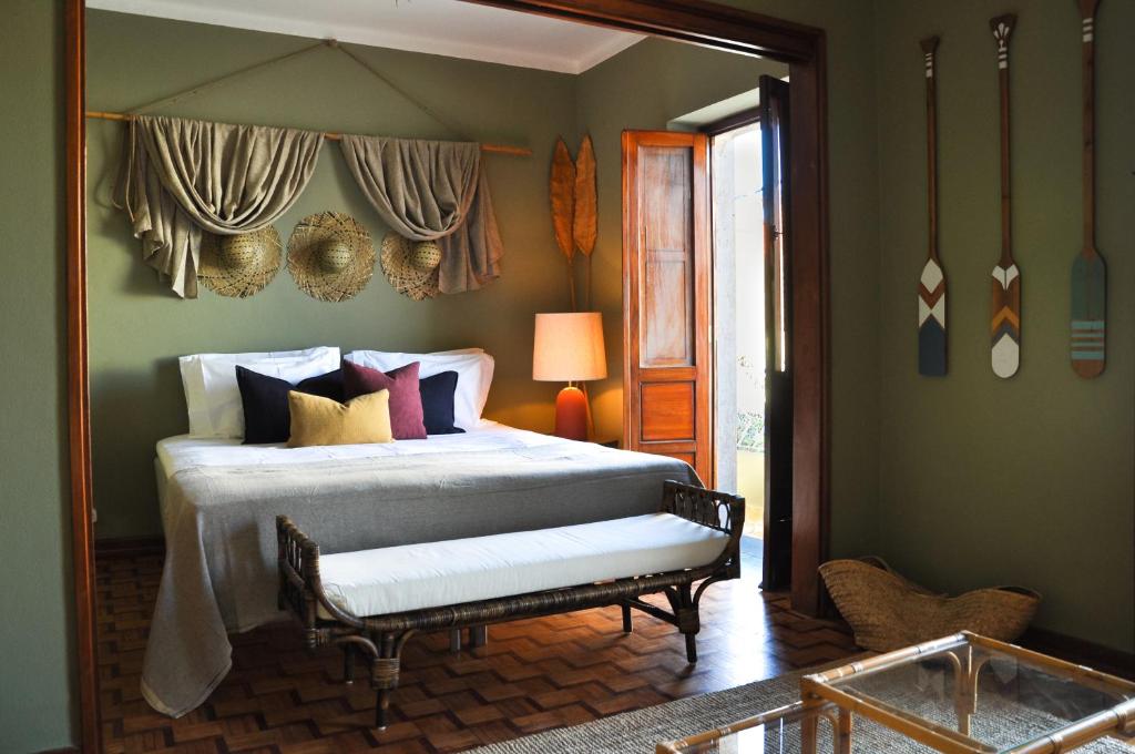 Dormitorio con cama con banco en Chic Suite Figueiras w balcony in Taviras Historical Centre, en Tavira
