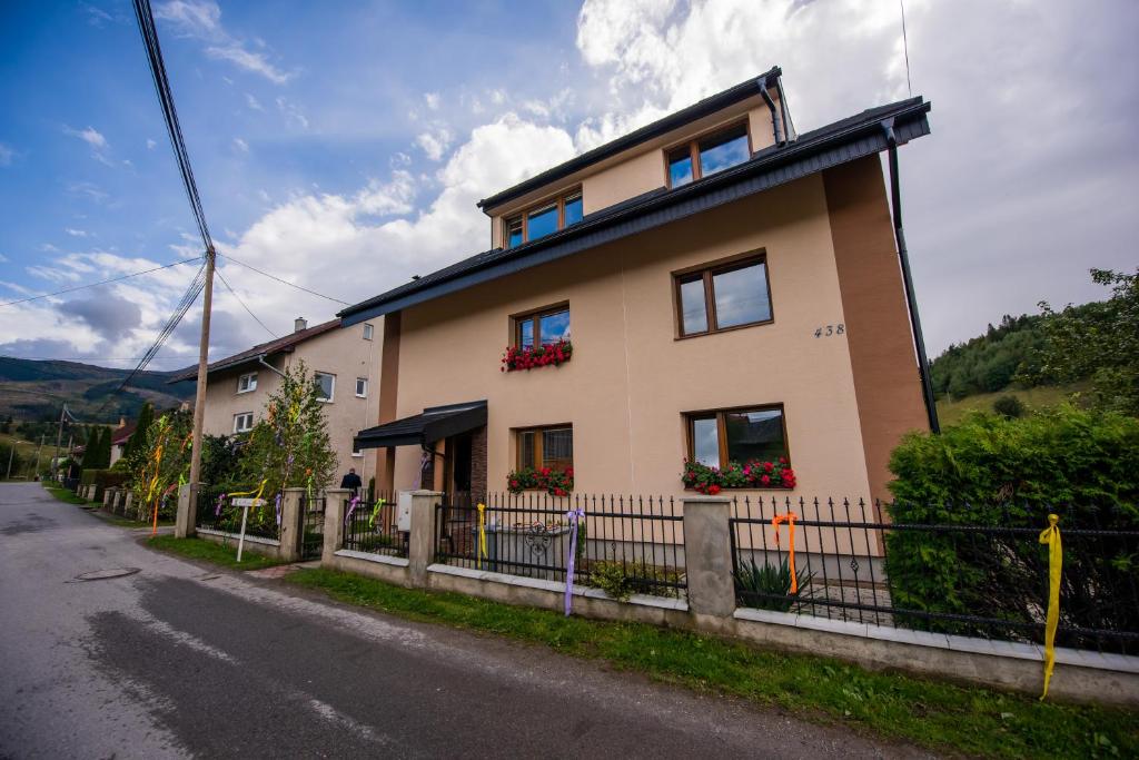 una casa con una valla al lado de una calle en Dom pri potoku en Zuberec