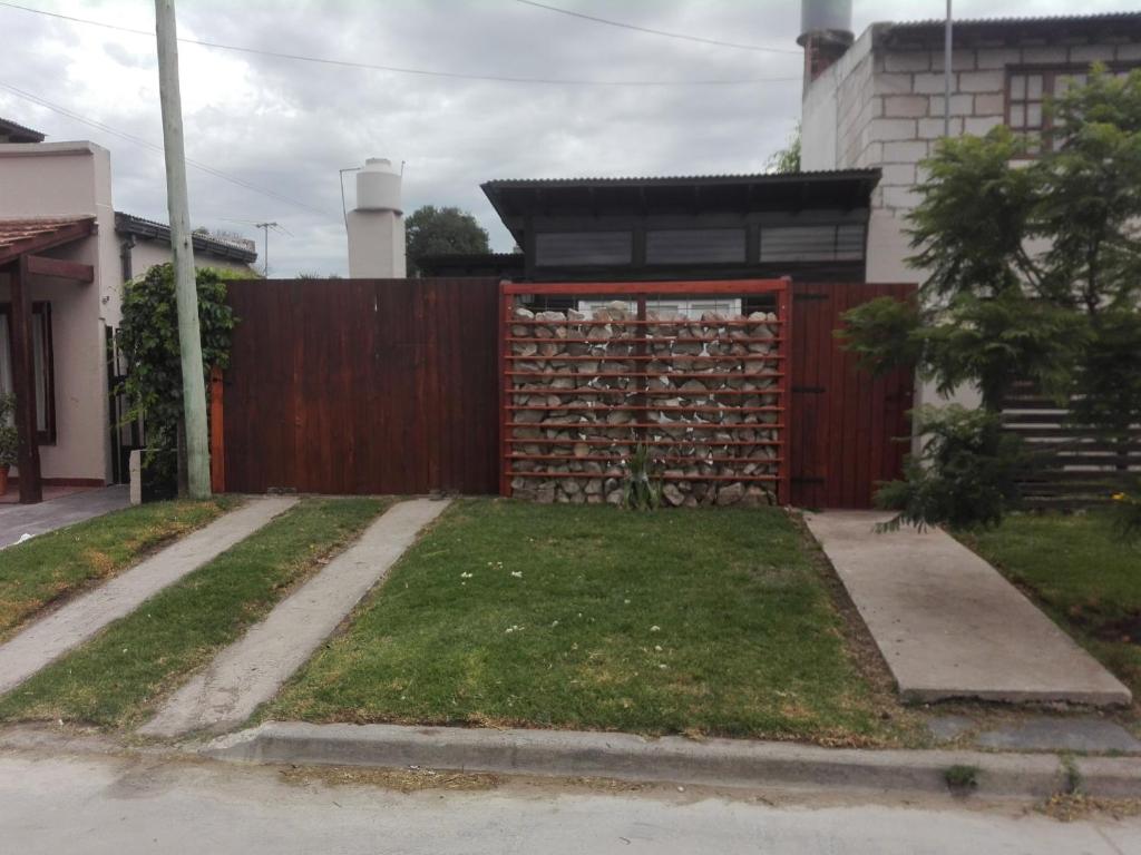 una valla de madera con una puerta roja en un patio en CABAÑA ÚNICA en Miramar