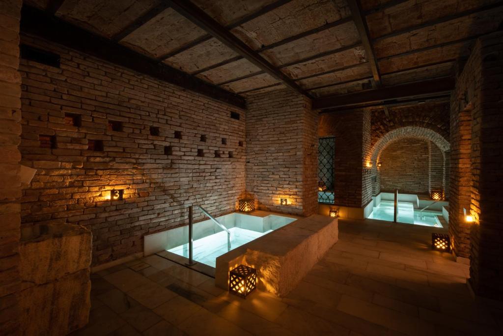 um quarto com uma banheira numa parede de tijolos em Azur Real Hotel Boutique & Spa em Córdoba