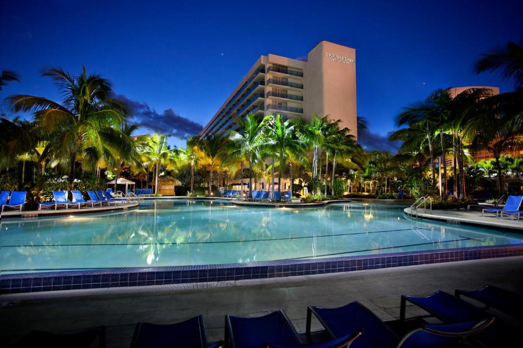 a large swimming pool with blue chairs and a hotel at DoubleTree Resort Hollywood Beach in Hollywood