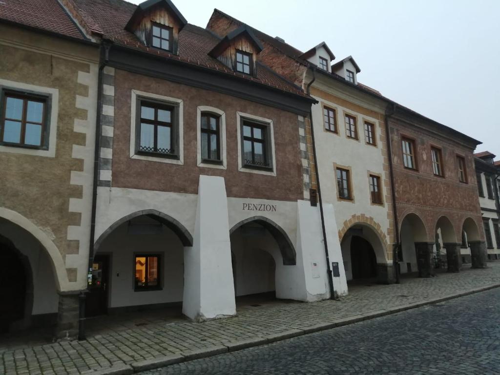 a building with arches on the side of a street at Bed&Bike Prachatice in Prachatice
