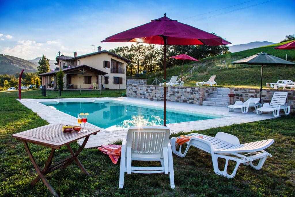 a backyard with a table and chairs and a pool at Agriturismo La Spiga D'Oro in Frontino