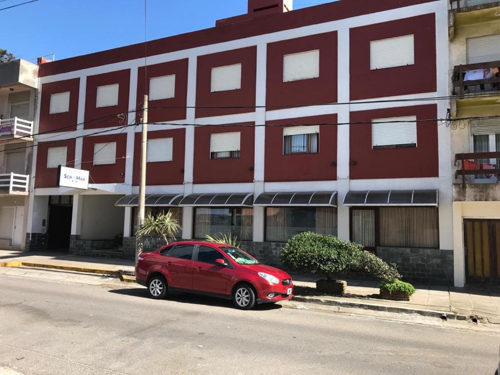 een rode auto geparkeerd voor een gebouw bij Hotel Ser-Mar in San Bernardo