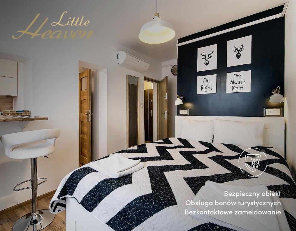 a bedroom with a black and white bed and a stool at Pfenning by Little Heaven in Gdańsk