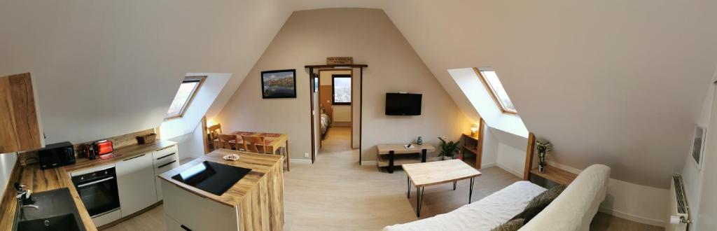 een woonkamer met een bank en een tafel in een kamer bij Aux chataigniers alpins in Gap