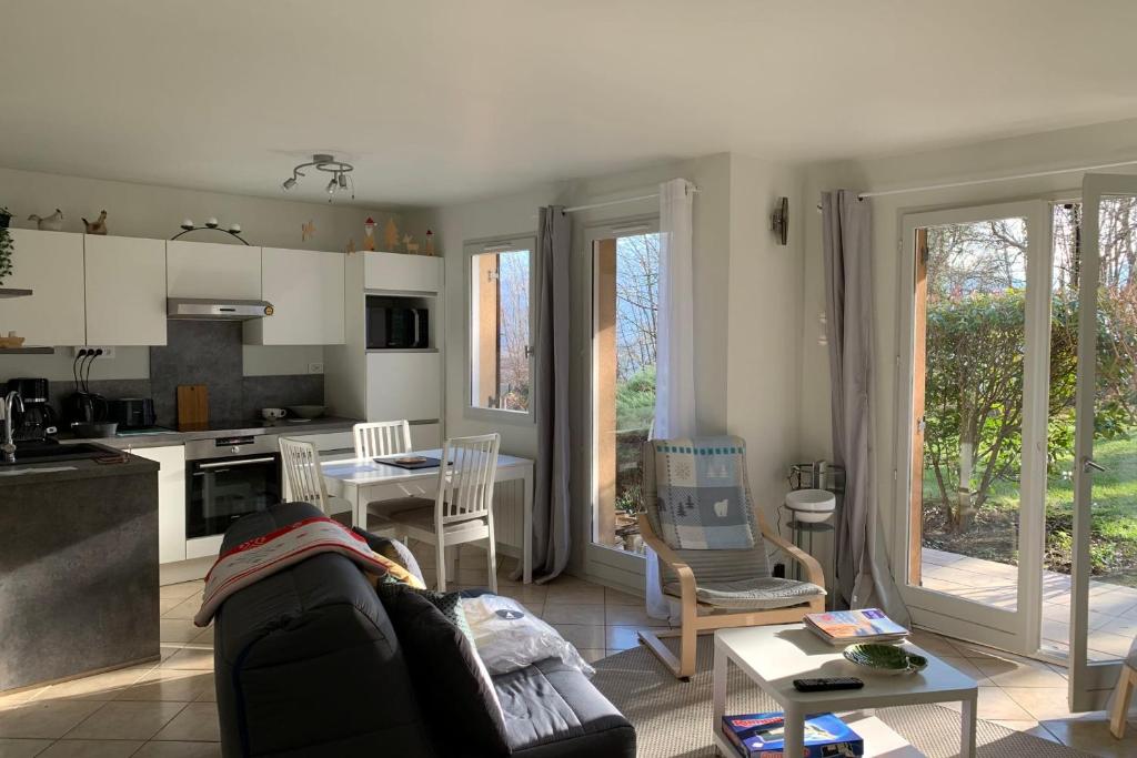 uma cozinha e sala de estar com um sofá e uma mesa em Le Montbonnot Luminous T2 Garden - Terrace #P0 em Montbonnot-Saint-Martin