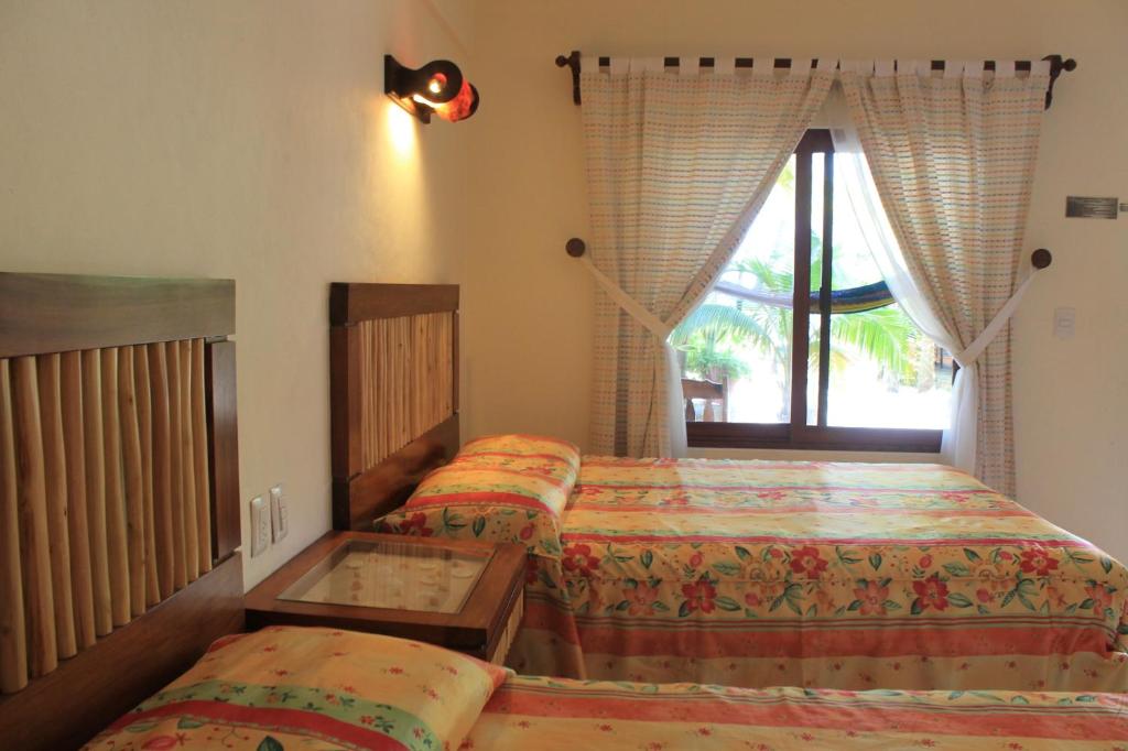 a bedroom with two beds and a window at Hotel Villa Kiin in Isla Mujeres