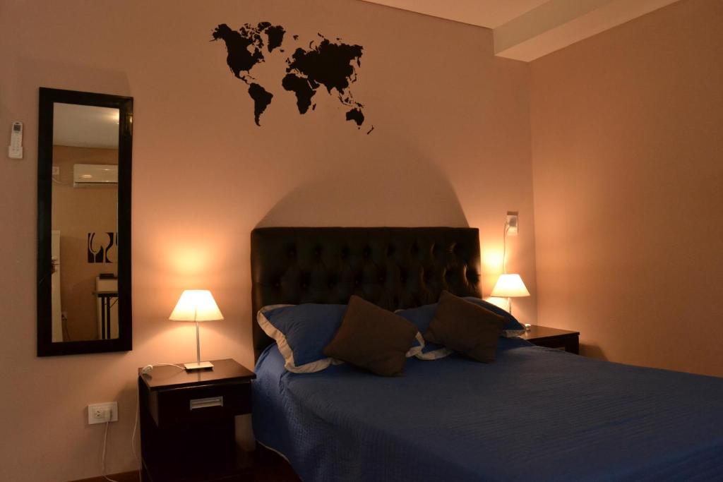 1 dormitorio con 1 cama con un mapa mundial en la pared en MendoApart en Mendoza