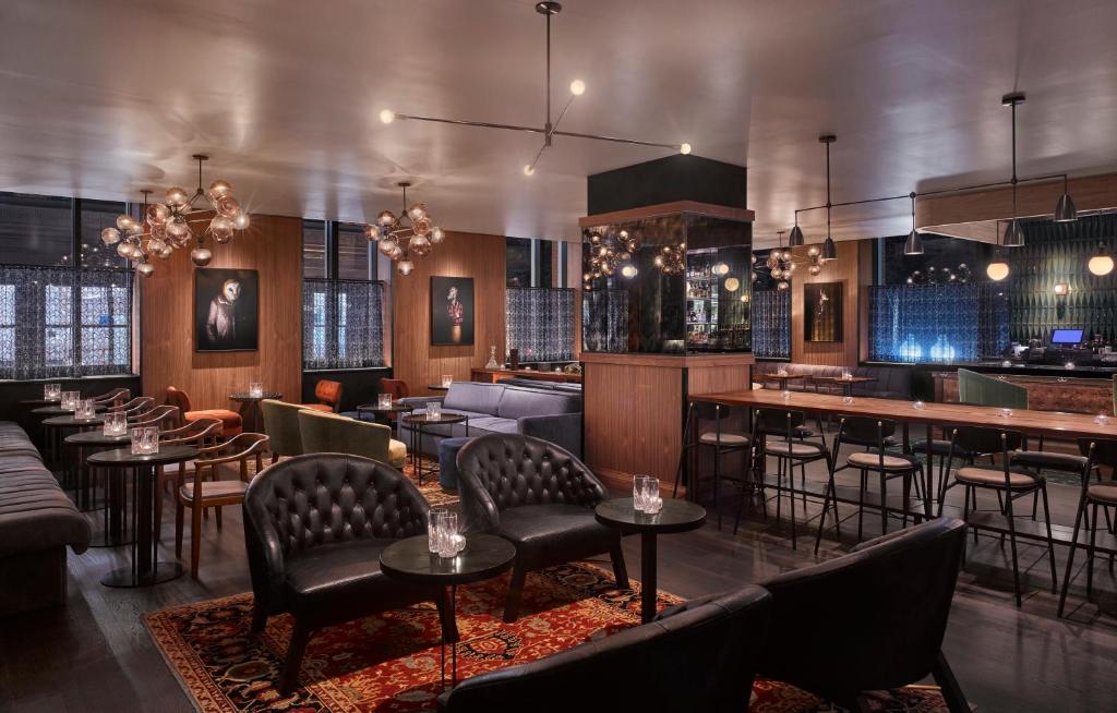 ein Restaurant mit Tischen und Stühlen und eine Bar in der Unterkunft Hotel AKA Boston Common in Boston