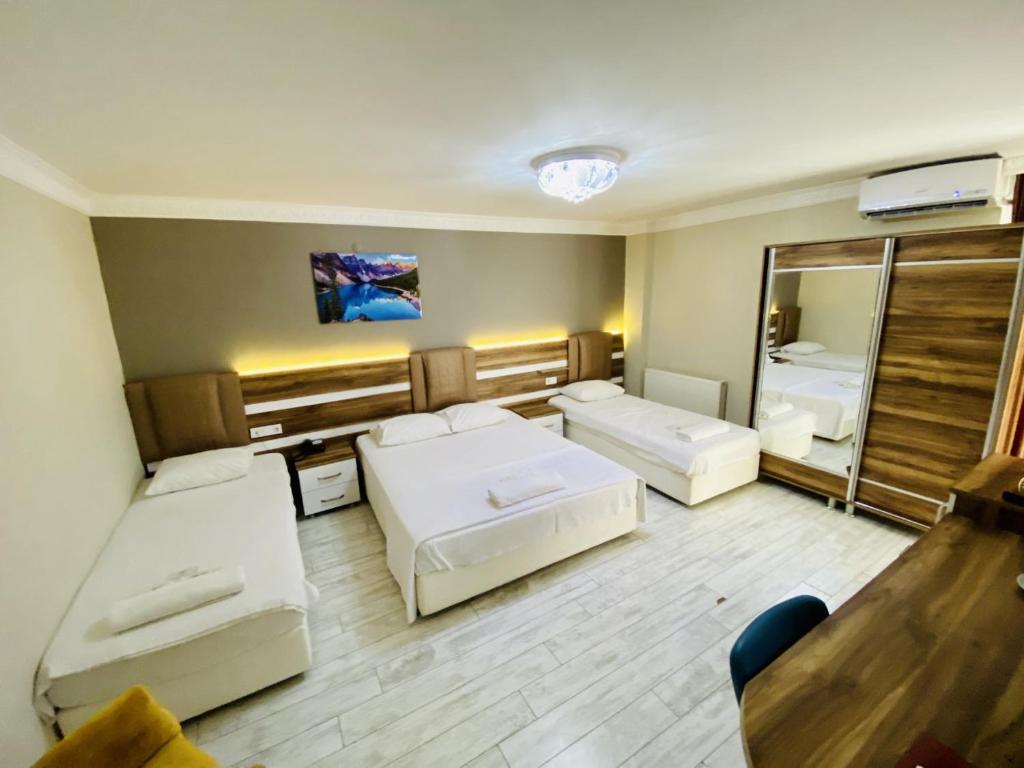 um quarto amplo com 2 camas e um espelho em ANKARA ATLANTİK OTEL em Etimesut