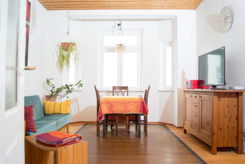 uma sala de jantar com uma mesa e um sofá em Altstadt Charme em Augsburg