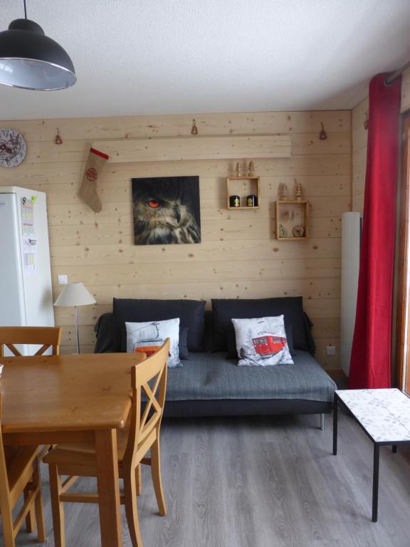 een woonkamer met een bank en een tafel bij APPARTEMENT PUY SAINT VINCENT ALPES DU SUD été - hiver in Puy-Saint-Vincent