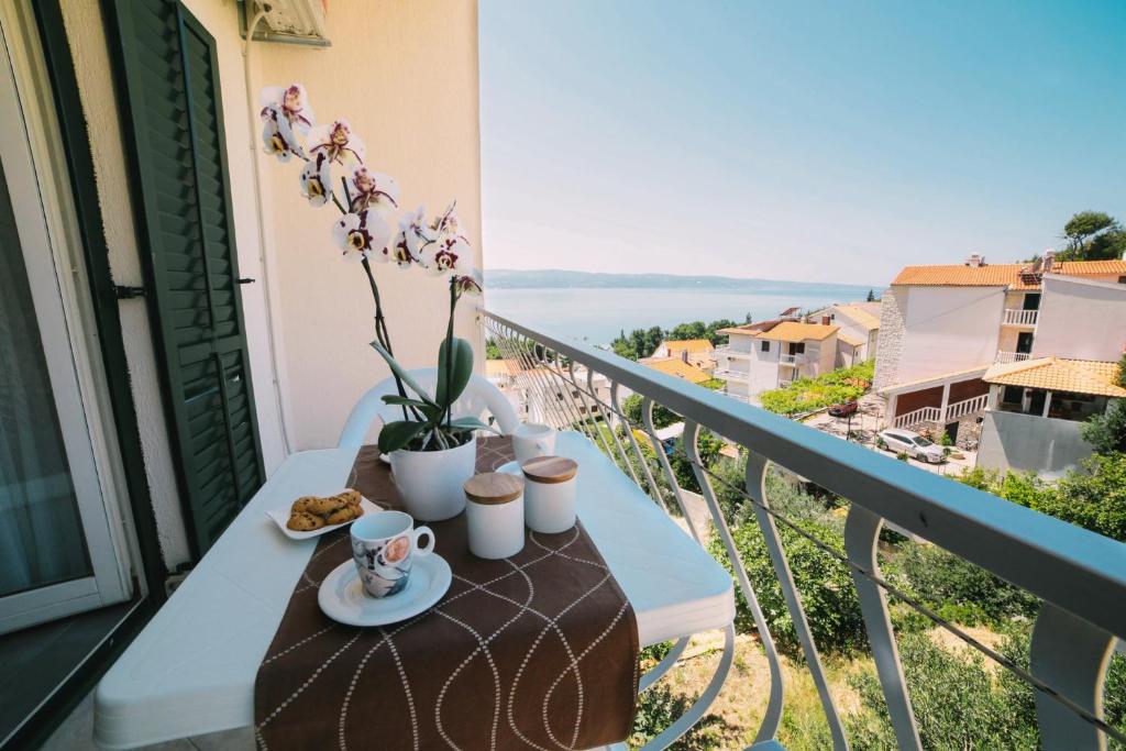 a table on a balcony with a view of the water at Villa Brigita in Omiš