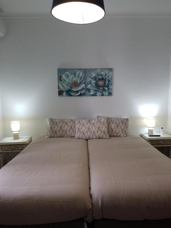 uma cama num quarto com duas lâmpadas em duas mesas em Moira - Alojamento Local em Reguengos de Monsaraz
