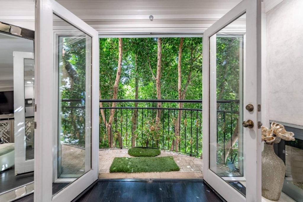 a room with doors open to a garden with trees at Barham Boutique Townhouse in Los Angeles