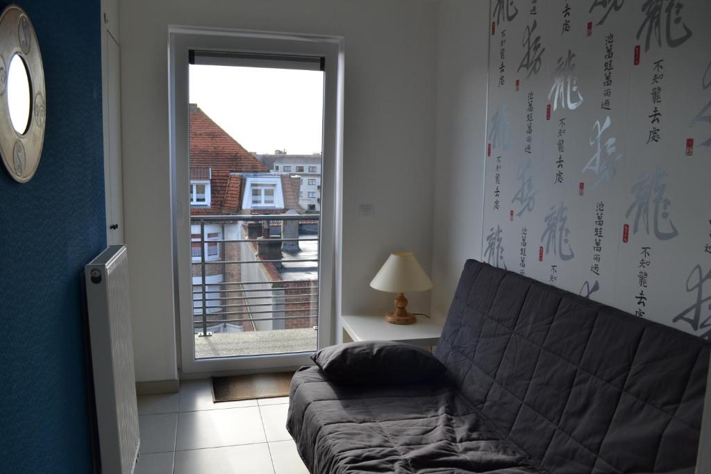 a living room with a couch and a window at Margaux in De Panne