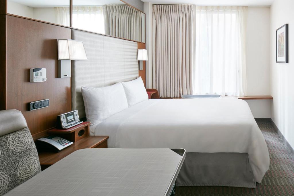 a hotel room with a large bed and a chair at Club Quarters Hotel Grand Central, New York in New York