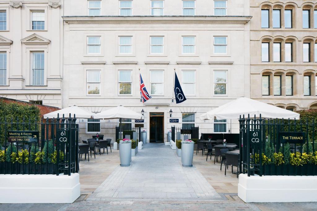 budynek ze stołami i parasolami przed nim w obiekcie Club Quarters Hotel Covent Garden Holborn, London w Londynie