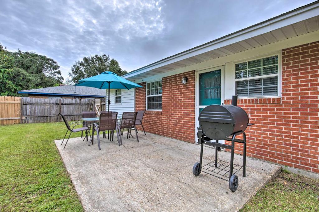 a grill on a patio with a table and chairs at Breezy Gulfport Getaway Less Than 1 Mile to Beach and Casino in Gulfport