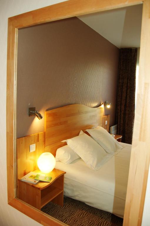 Postel nebo postele na pokoji v ubytování Hôtel Cositel, CIT'HOTEL Coutances