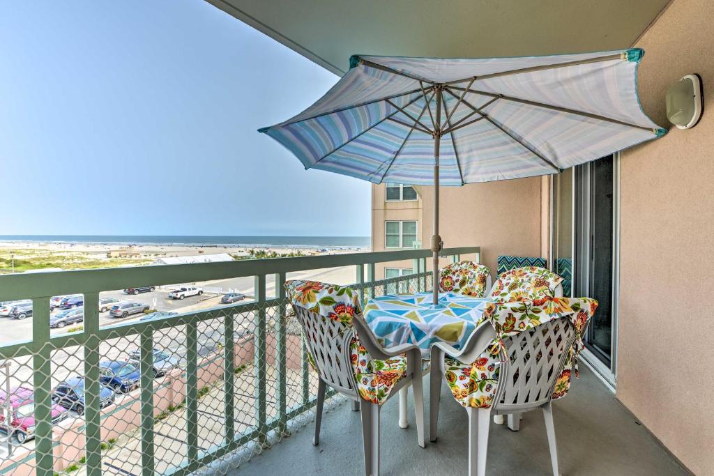 Oceanfront Resort, Year-Round Pools, Private Beach في وايلدوود كريست: شرفة مع طاولة وكراسي ومظلة