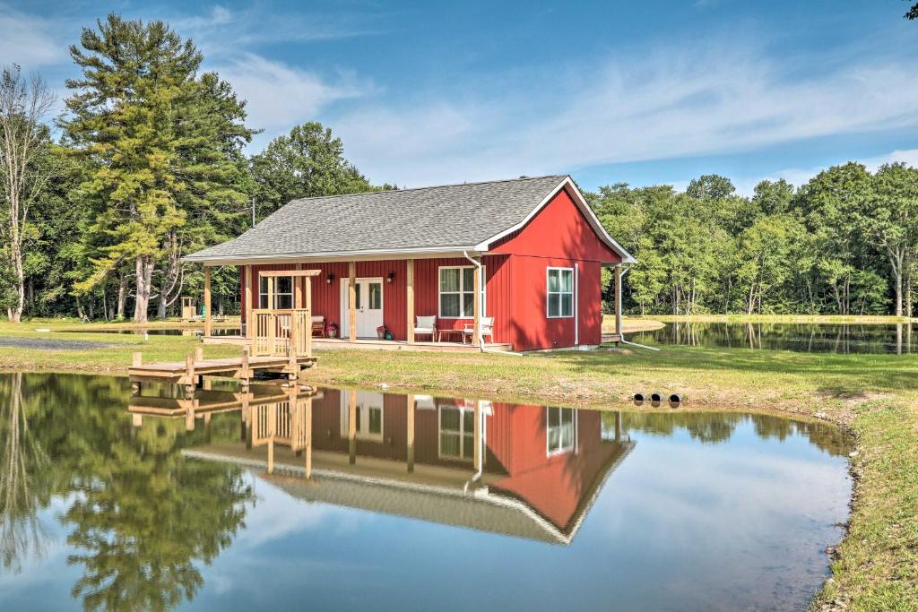 uma cabina vermelha com um reflexo na água em Waterfront Cottage 15 Mi to Camelback Mountain em Brodheadsville