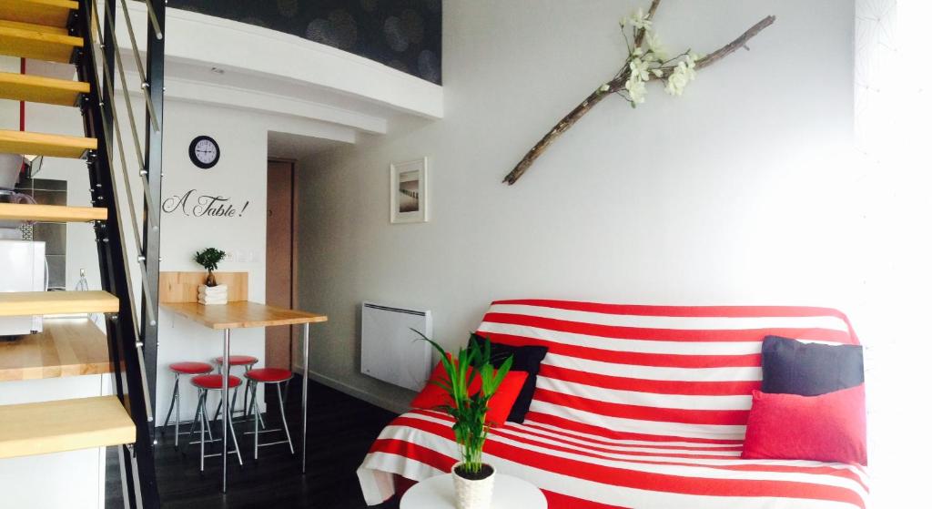 a living room with a red and white striped couch at Halte cosy au porte de Bordeaux in Tresses