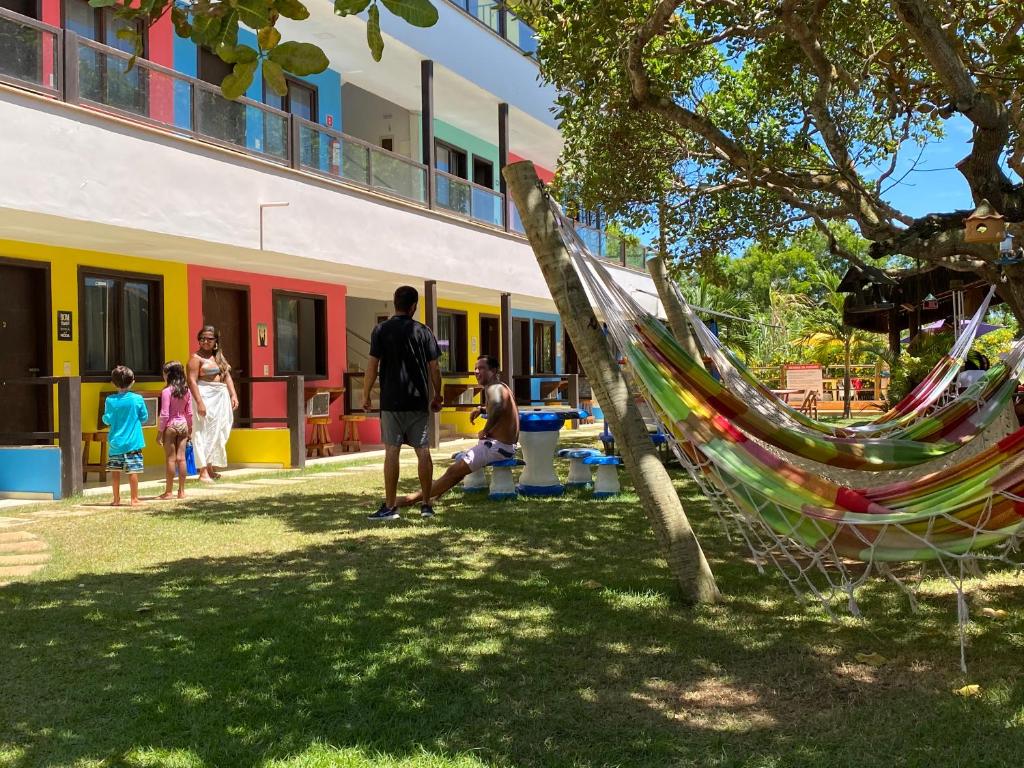 a group of people standing in a yard with a hammock at Pousada Toca do Ceará in Regencia Augusta