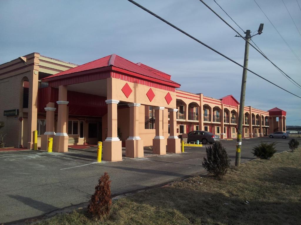 a large building with a red roof on a street at Garden Inn and Extended Stay in Shepherdsville
