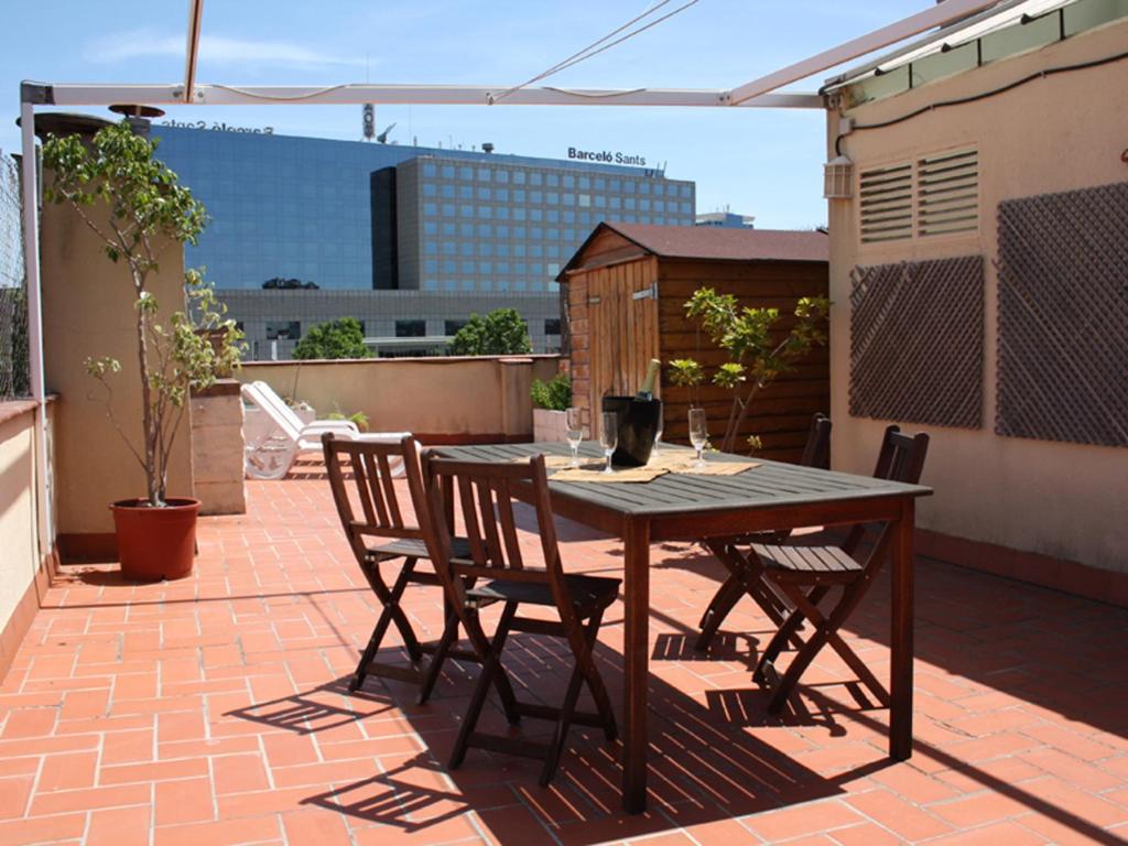 einen Holztisch und Stühle auf einer Terrasse in der Unterkunft Penthouse Vallespir in Barcelona