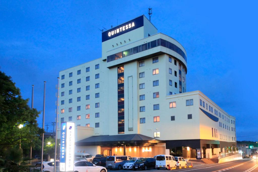 ein Hotelgebäude mit auf einem Parkplatz geparkt in der Unterkunft Quintessa Hotel Iseshima in Shima