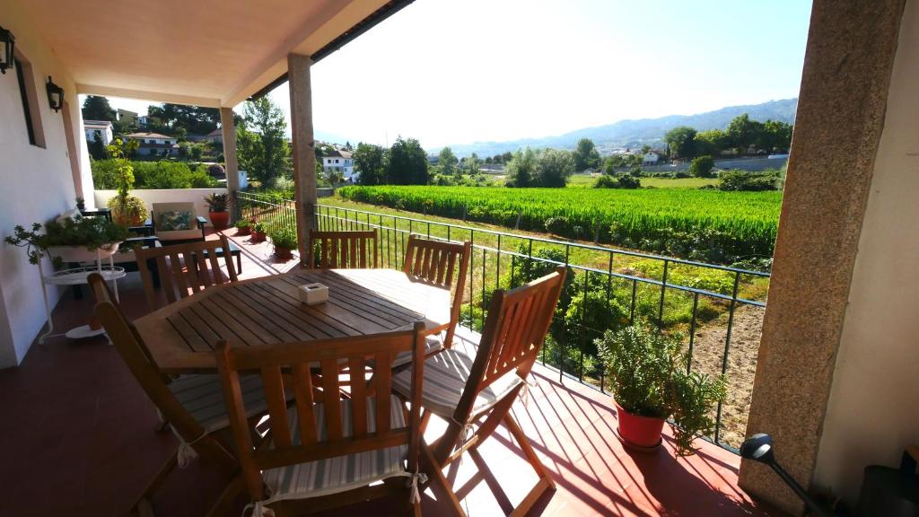 einen Balkon mit einem Tisch und Stühlen sowie einem Weinberg in der Unterkunft Quinta do Arieiro in Arouca