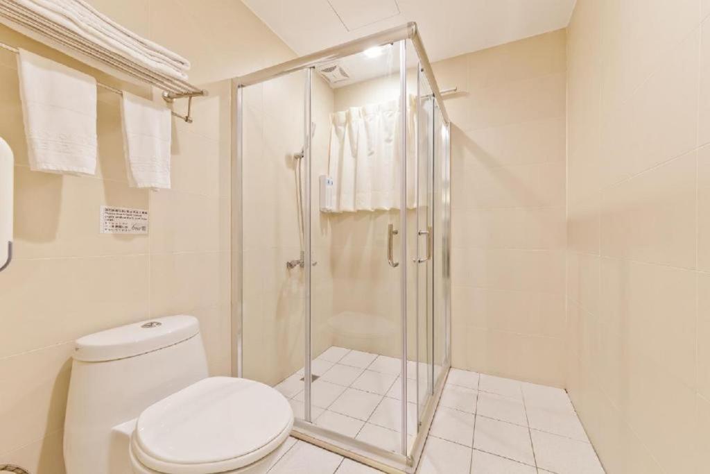 a white bathroom with a shower and a toilet at Hotel 6 - Ximen in Taipei