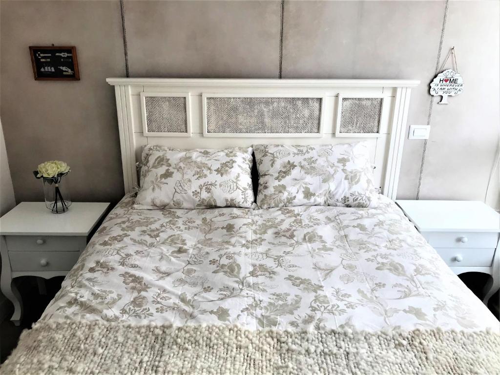 um quarto com uma cama com uma colcha e almofadas brancas em Concón Costa de Montemar Departamento, 3 dormitorios em Concón
