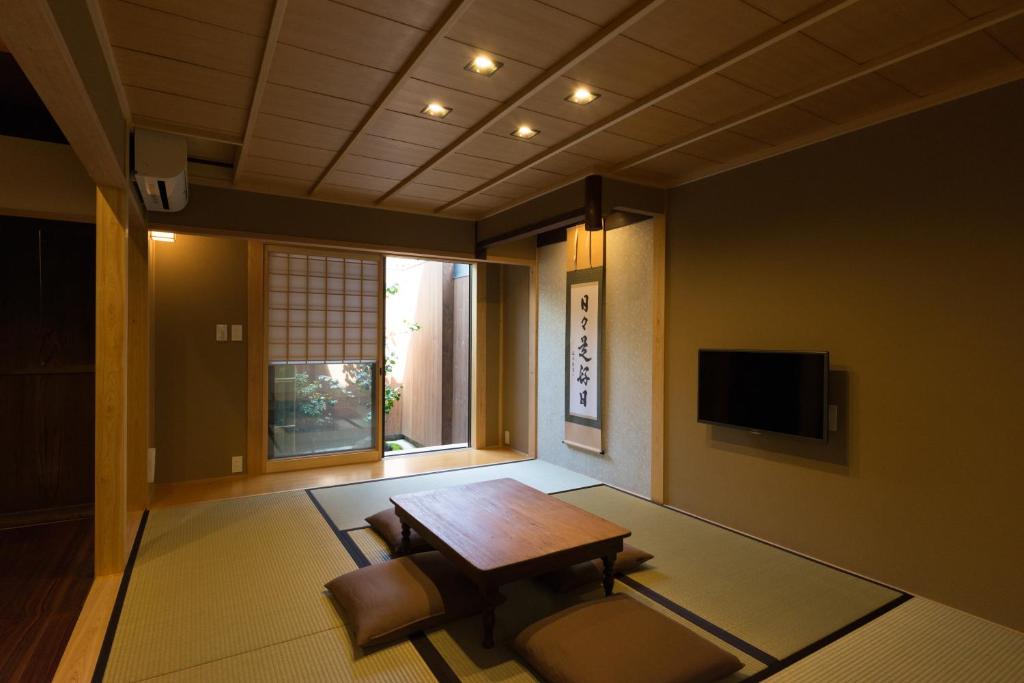a living room with a table and a tv at Rikyu-an Machiya House in Kyoto