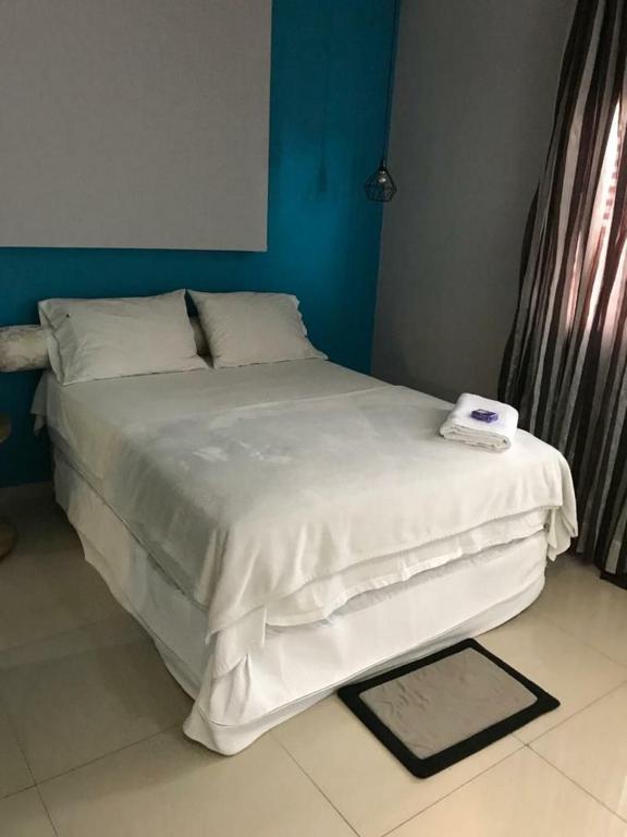 a bedroom with a large bed with white sheets at #01 Boulevard Amazon Suites in Manaus
